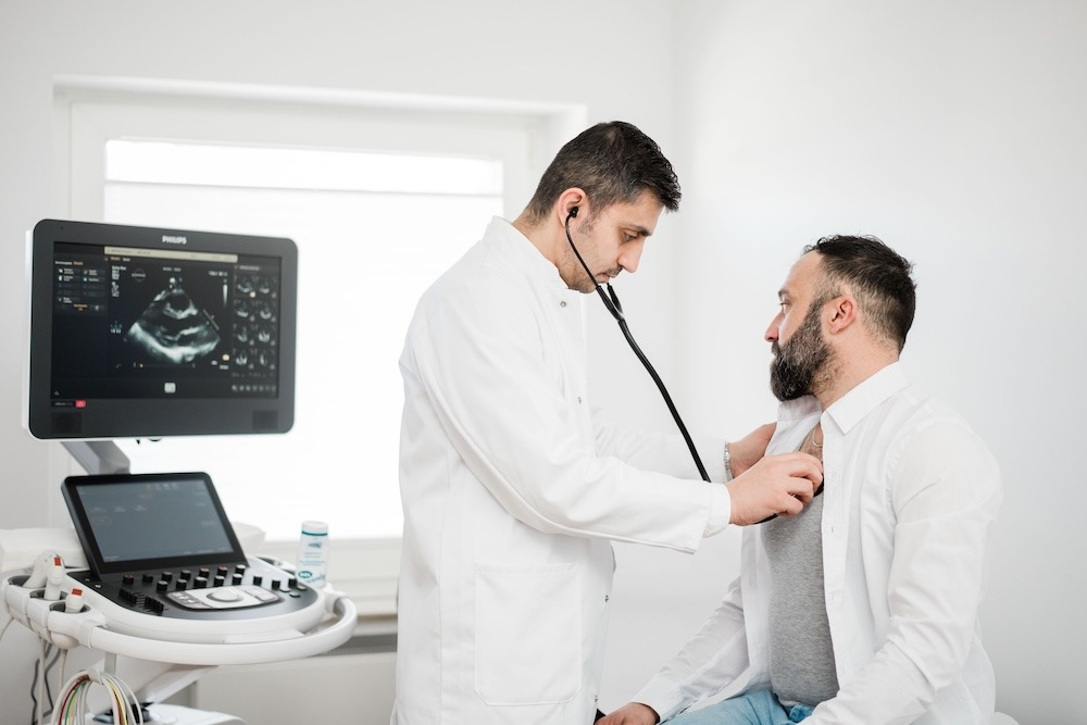 Herz-Check-up Untersuchung beim Kardiologen in Düsseldorf Herz-Check-up: Kardiologe untersucht einen Patienten mit dem Stethoskop in Düsseldorf